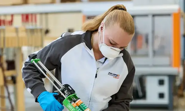 Een deelnemer werkt met een kitpistool aan een werkbank bij LUX038.